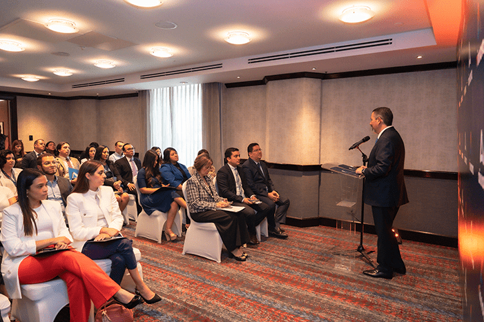 Conferencista frente a público, hablando sobre AINNOVA