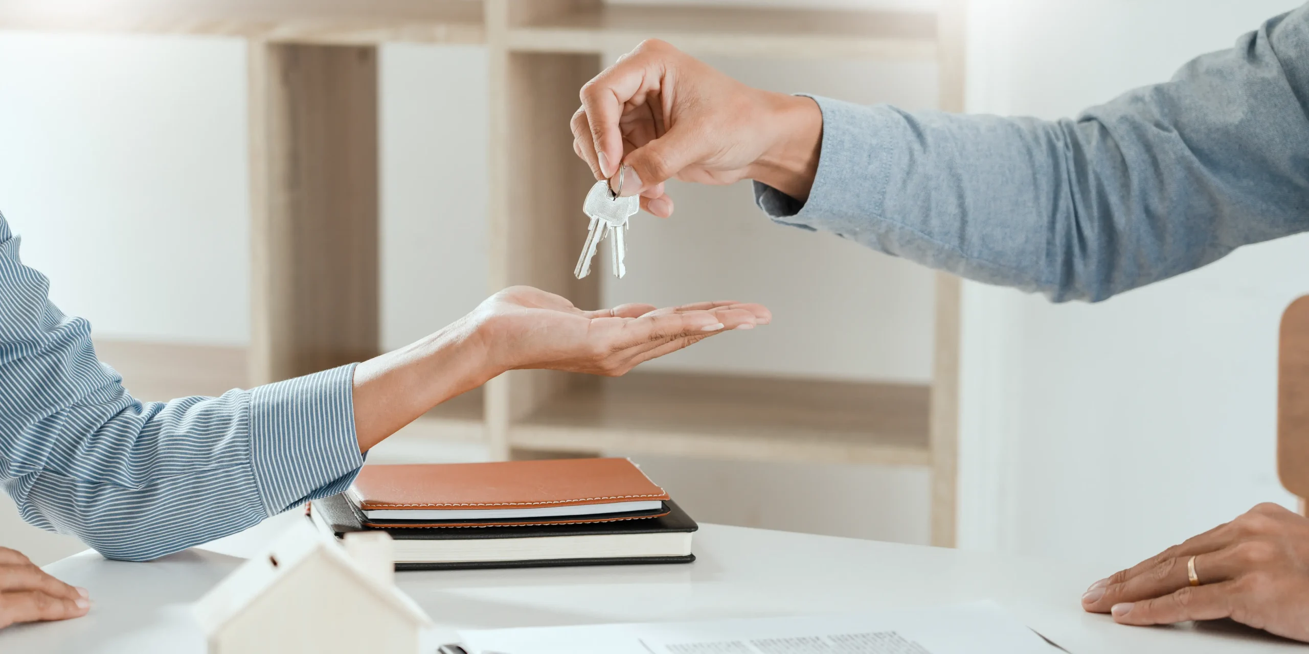 Persona entregando llaves de casa a otra persona