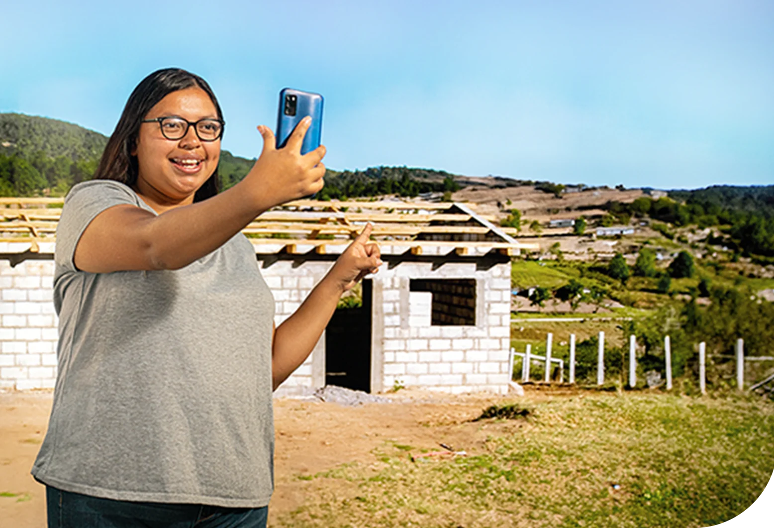 Persona tomando una selfie frente a una construcción.