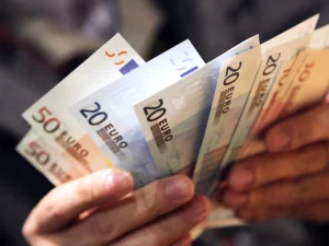 Un hombre cuenta billetes de euro.